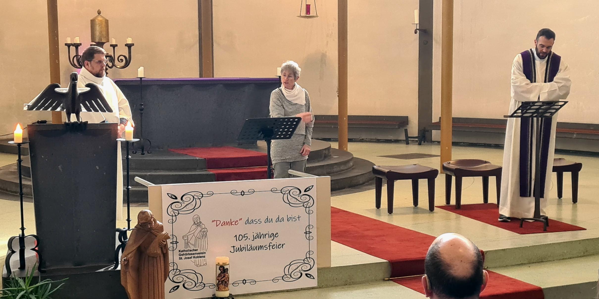 Gottesdienst in einer Kirche: Drei Personen vorne im Altarraum, davor Gäste bei einer Jubiläumsfeier.