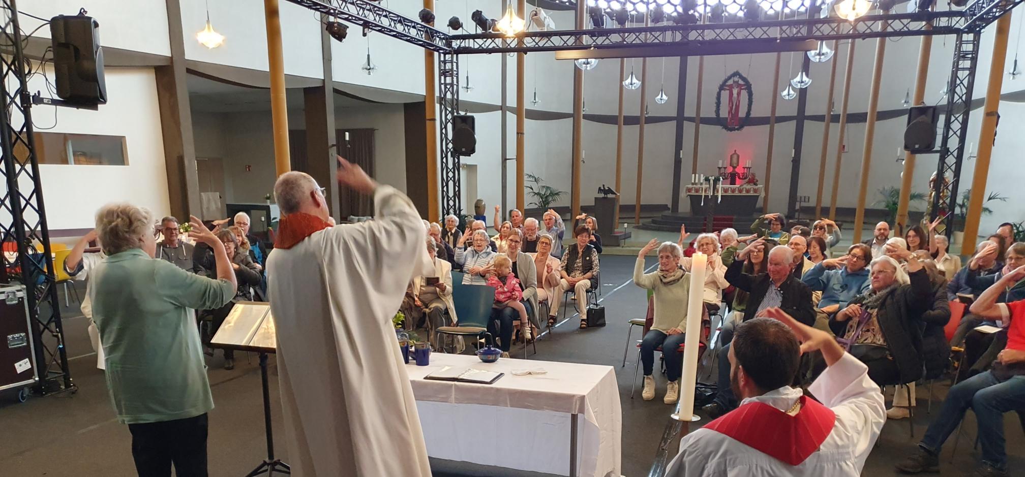 Gläubige versammeln sich um einen zentralen Altar in einem hellen, kreisförmigen Kirchenraum.