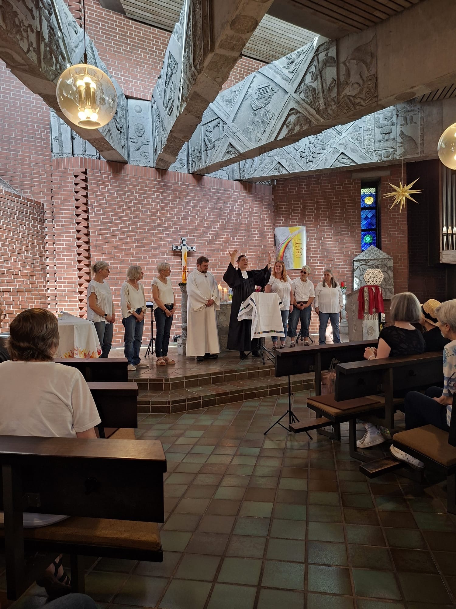Gebärdenchor tritt vor der Gemeinde im Altarraum einer Kirche auf und gestaltet ein Lied.